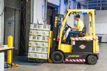 Stock photo of forklift moving boxes